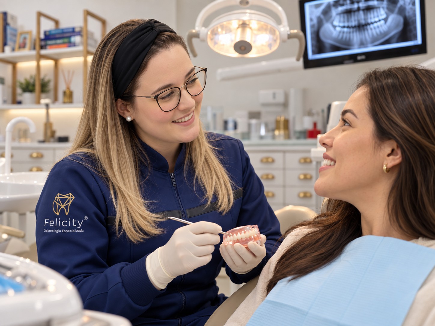 Dra. Juliana explicando o procedimento com calma para a paciente, usando um modelo de dentes